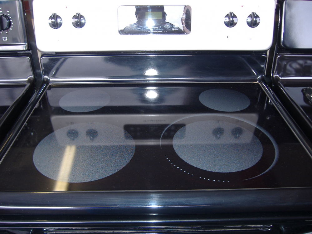 A stove with a shiny flat cooktop