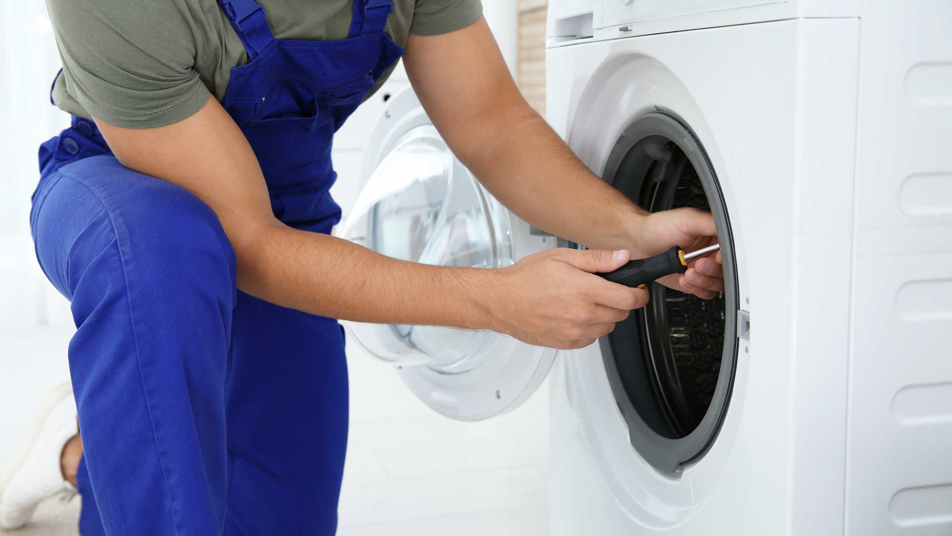 A man repairing a clothes washer