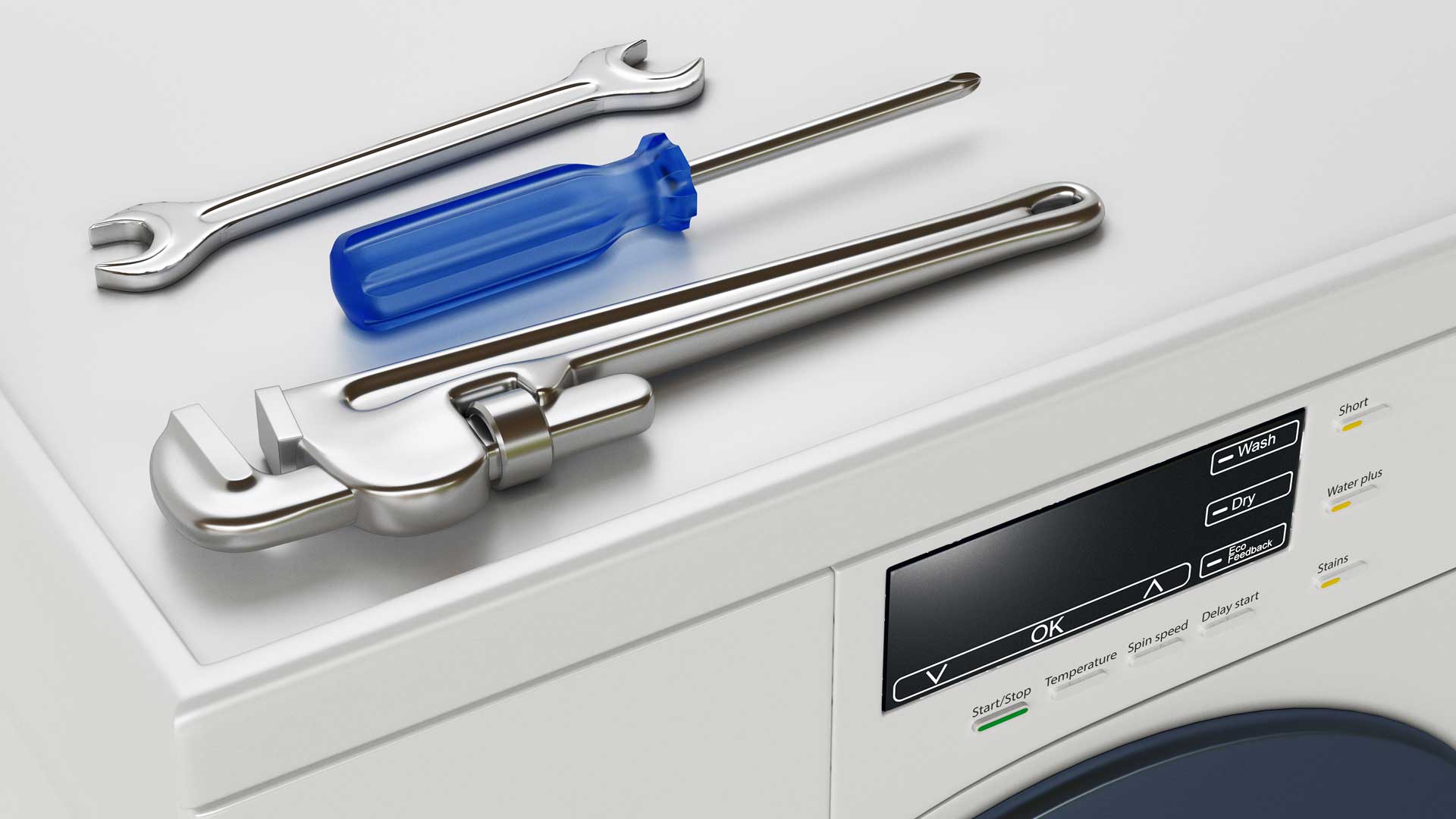 Close-up of a clothes washer with some tools sitting on top of it